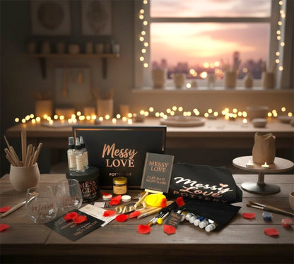 Table with 'Messy Love' products and decor items in a cozy room with string lights and a sunset view.